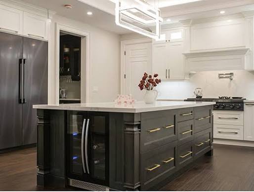 Custom shaker kitchen island with dark charcoal cabinets, brass handles and wine fridge